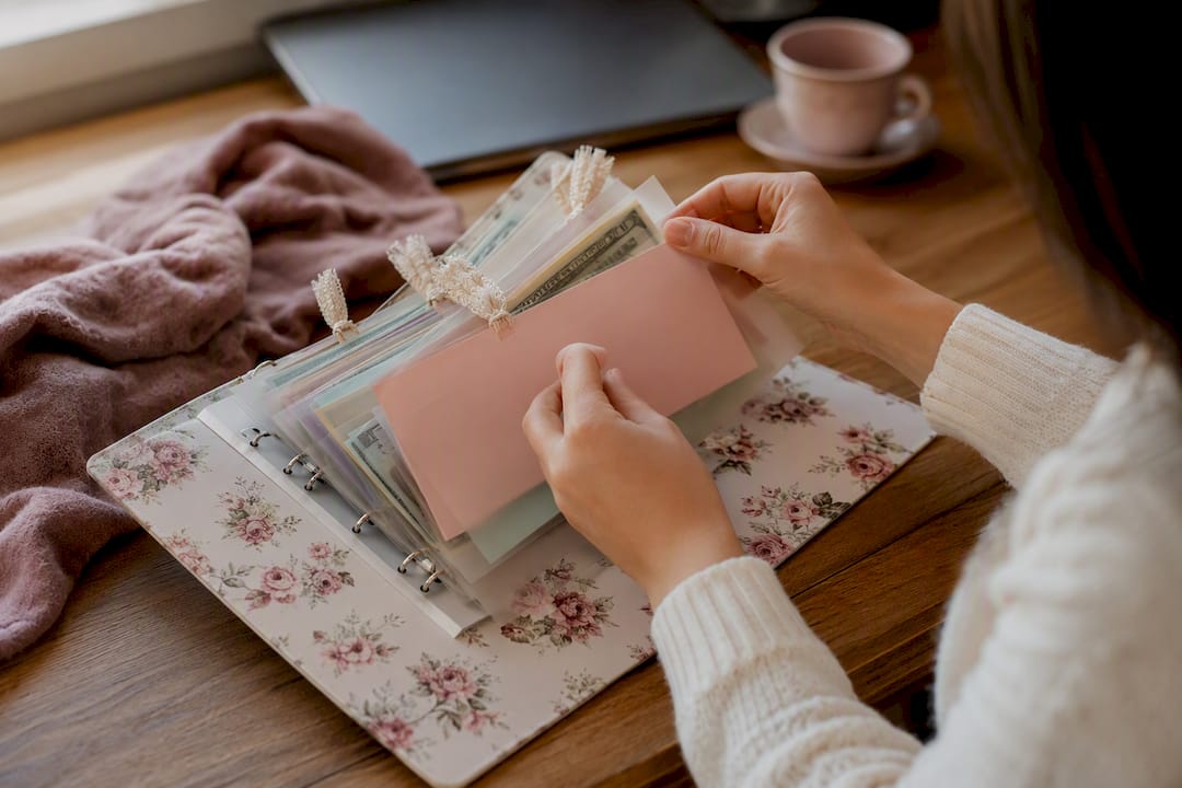 Hands arranging cash envelopes in wedding budget binder